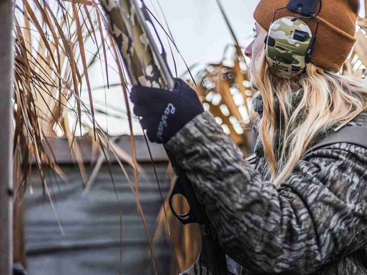 Woman hunting while wearing Walker's earmuffs as ear protection