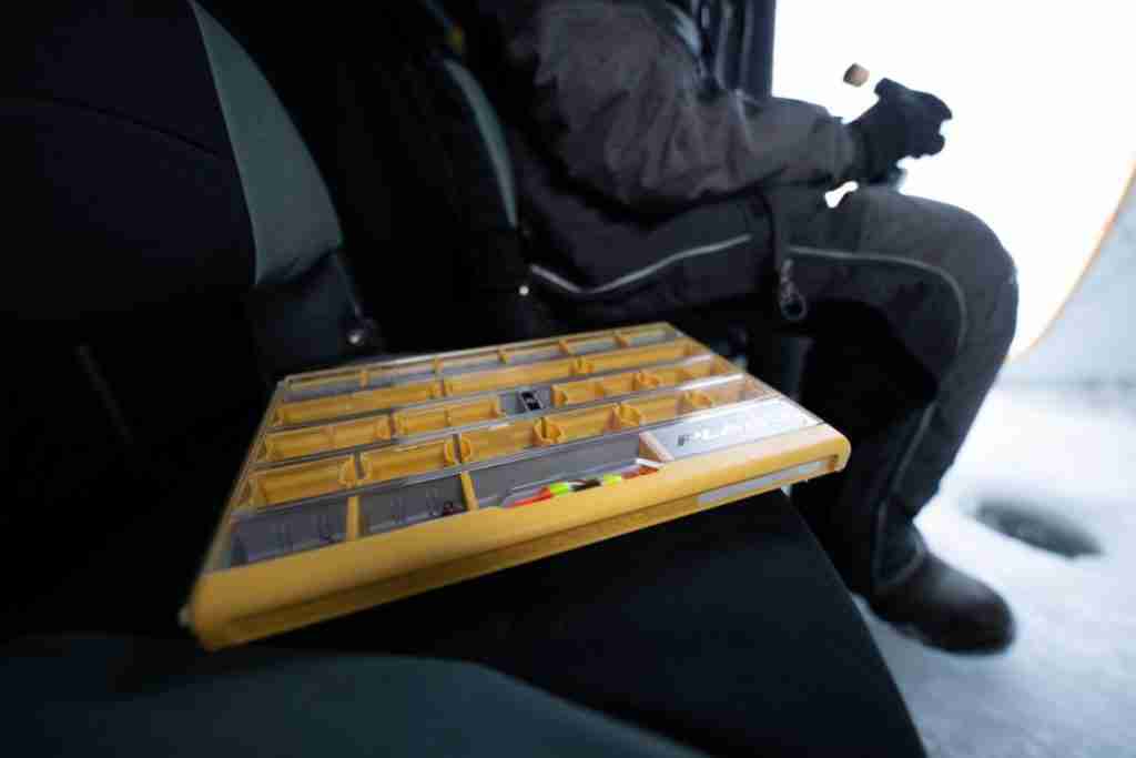 Ice fishing tackle box for spare line, hooks, sinkers, bait, and lures.