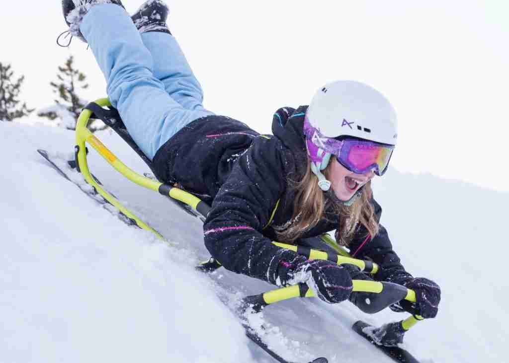 Young girl having a blast sledding down snowy slope on a Yukon Charlie’s Hammerhead Pro HD Sled