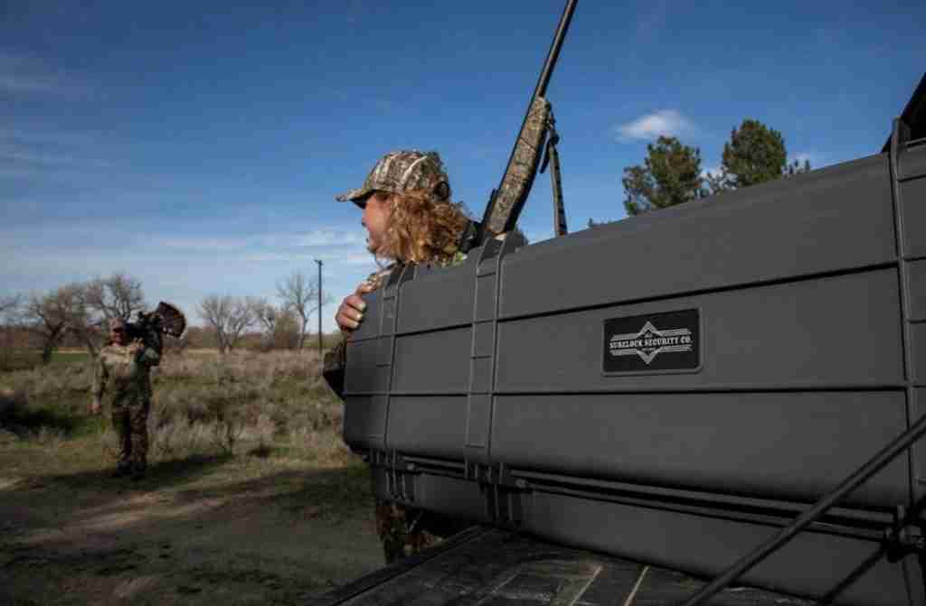 Two hunters in camouflage use a Surelock Security gun case for their hunting rifles. 