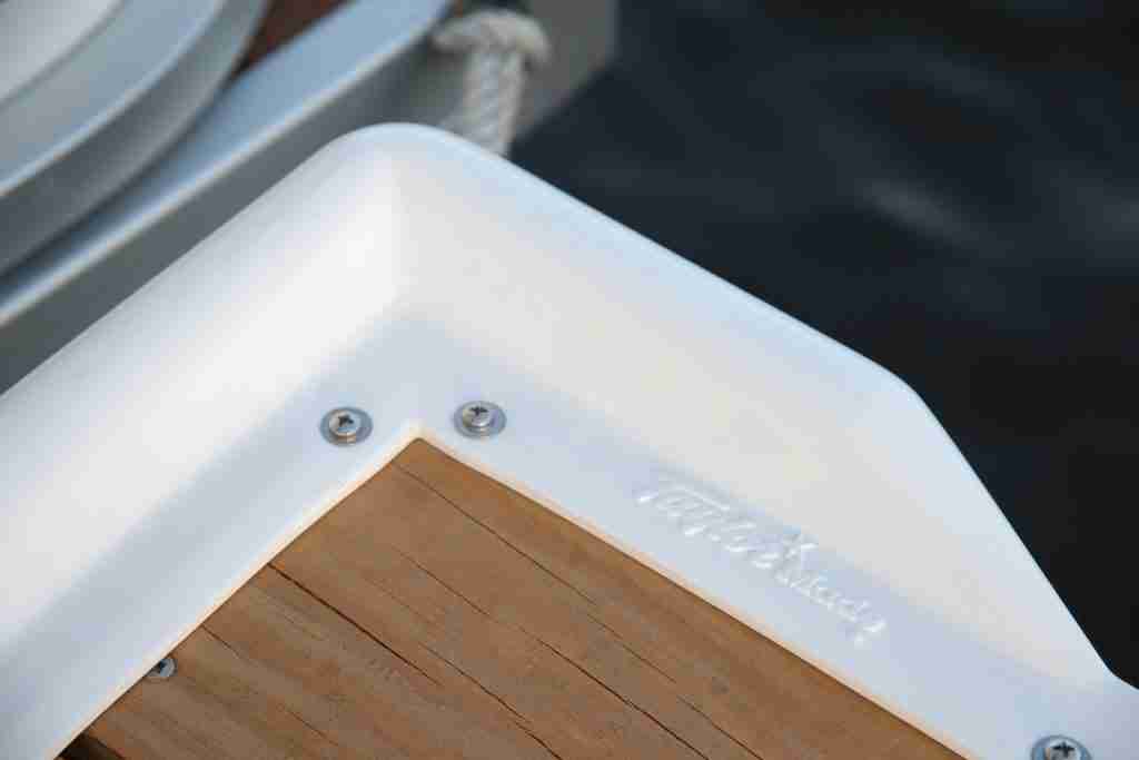 A dock bumper on the corner of a dock provides protection to a boat nearby. 